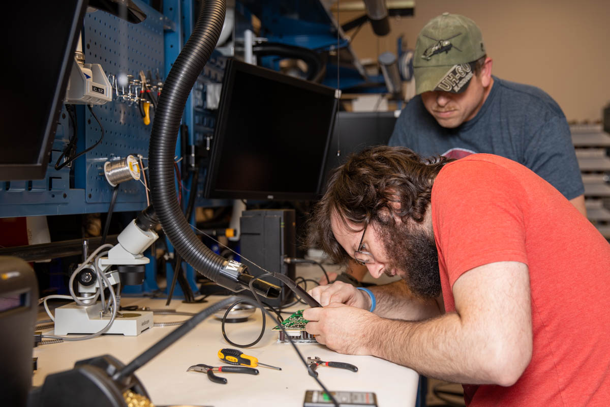 Two men working on computer motherboards